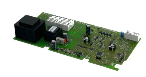 Regelungsplatine von Wolf mit verschiedenen elektronischen Bauteilen, darunter Widerstände, Kondensatoren und Relais, auf einer grünen Leiterplatte.